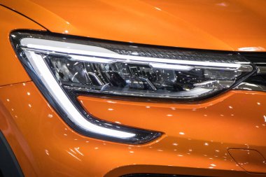 Poznan, Polonya - 08 Nisan 2022: Poznan Motor Fuarı. Turuncu Renault Arkana 'nın parlayan lambalarına bakın. Ayrıntı ve aracın parçası
