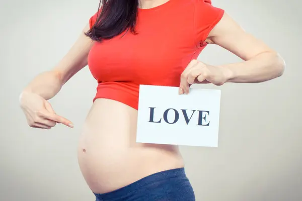 Γυναίκα Έγκυο Κρατώντας Λευκή Κάρτα Επιγραφή Αγάπη Αναμένεται Γέννηση Νεογέννητου Royalty Free Εικόνες Αρχείου