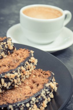 Siyah tabakta taze pişmiş kabak hamuru ve bir fincan beyaz kahve. Tatlı nefis.