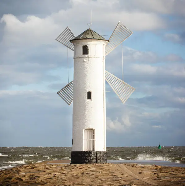stock image Swinoujscie, West Pomeranian - Poland - June 13, 2021: Windmill Stawa Mlyny and sea with big waves. Navigational mark. Stormy and windy day