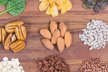 Sağlıklı besleyici yiyecekler ve ahşap kesme tahtasındaki çeşitli malzemeler. Doğal magnezyum, beslenme lifleri ve diğer mineraller