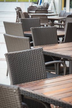 Şehir merkezindeki açık hava restoranında ya da kafede hasır ya da rattan sandalyeler ve masalar. Rahatlama zamanı.