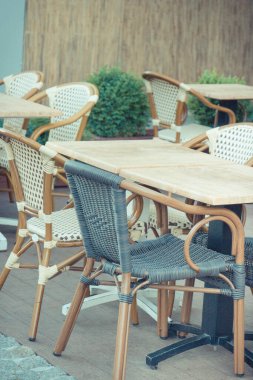 Şehir merkezindeki açık hava restoranında ya da kafede hasır sandalyeler ve masalar. Rahatlama zamanı.