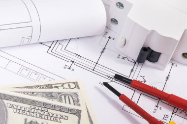 Elektrik tesislerinde kullanılan elektrik parçaları, inşaat şemaları, iş aletleri ve dolar banknotları. Ev yapmayı ya da almayı planlama kavramı. Teknoloji