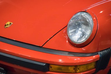 Poznan, Polonya - 07 Ekim 2023: Retro Motor Show. Poznan 'daki Uluslararası Fuar. Parlak, eski, klasik kırmızı Porsche 911 'in önünde. Ayrıntı ve aracın parçası