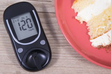 Glukometre, şeker seviyesini kontrol etmek için kullanılıyor. Fırında pişmiş çikolatalı kek. Diyabet konsepti sırasında besin