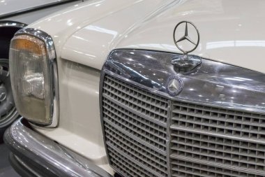 Poznan, Polonya - 07 Ekim 2023: Retro Motor Show. Poznan 'daki Uluslararası Fuar. Parlak eski klasik beyaz Mercedes W108 'in önünde bakın. Ayrıntı ve aracın parçası