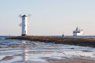 Swinoujscie, Batı Pomeranya - 14 Haziran 2021: Swinoujscie 'den Ystad' a giden yolcu ve araba feribotlarına bakın. Baltık Denizi 'nden nakil. Stawa Mlyny yel değirmeninde gün doğumu