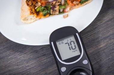 Glikoz ölçer, şeker seviyesi ve taze pişmiş vejetaryen pizzanın iyi bir sonucu. Diyabet konsepti sırasında besin