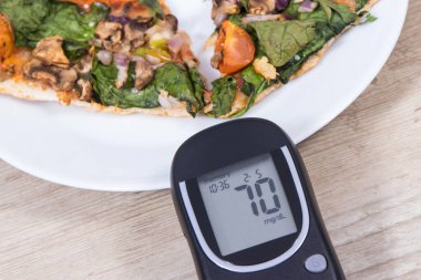 Glikoz ölçer, şeker seviyesi ve taze pişmiş vejetaryen pizzanın iyi bir sonucu. Diyabet konsepti sırasında besin