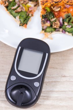 Glukometre şeker seviyesini taze pişmiş vejetaryen pizzayla ölçmek ve kontrol etmek için. Diyabet konsepti sırasında besin