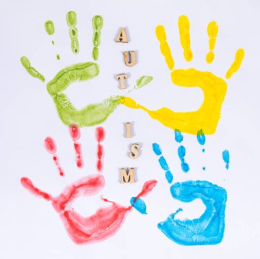 Beyaz arka planda boyadan yapılmış renkli çocuk el izi. Otizm spektrum bozukluğu konsepti. Otizm farkındalığı