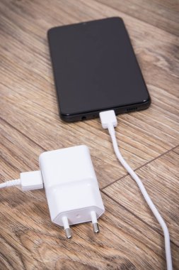 Siyah akıllı telefon, şarjlı cep telefonu. Çeşitli aygıtlar şarj etme kavramı