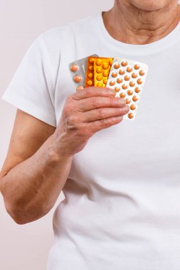 Elinde tablet ya da takviye malzemelerle yaşlı bir kadın. Tedavi ya da yaşlılıkta bağışıklığın güçlendirilmesi. Sağlık hizmetleri