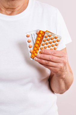 Elinde bir paket tabletle yaşlı yaşlı bir kadın. Vitamin, takviye veya antibiyotik. Tedavi ya da yaşlılıkta bağışıklığın güçlendirilmesi. Sağlık hizmetleri