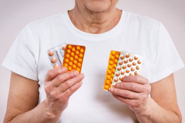 Elinde tablet, vitamin ya da takviye malzemesi olan yaşlı bir kadın. Tedavi ya da yaşlılıkta bağışıklığın güçlendirilmesi. Sağlık hizmetleri