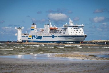 Swinoujscie, Batı Pomeranya - 15 Temmuz 2022: Trelleborg 'dan Swinoujscie' ye giden Nils Dacke feribotu yolcuları ve arabaları izleyin. Stawa Mlyny yel değirmeninde rüzgarlı bir gün. Baltık Denizi 'nden Nakliye
