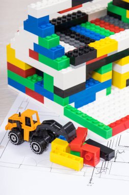 Elektrik tesisatı olan konut planı, renkli oyuncak bloklardan yapılmış yapım aşamasındaki ev. Konut inşa etme ya da kiralama konusu