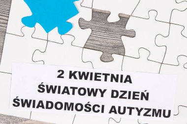 Beyaz ve mavi yapboz ve 2 Nisan Dünya Otizm Farkındalık Günü Otizm Spektrum Bozukluğunun sembolü olarak yazıyı cilala