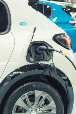 Poznan, Polonya - 08 Nisan 2022: Poznan Motor Fuarı. Ak elektrikli Peugeot e-208 şarj prizi takılı. Elektrikli araca yükleme işlemi