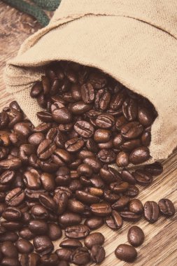 Kavrulmuş, kavrulmuş kahve çekirdekleri. Ahşap arka plan. Vintage fotoğraf