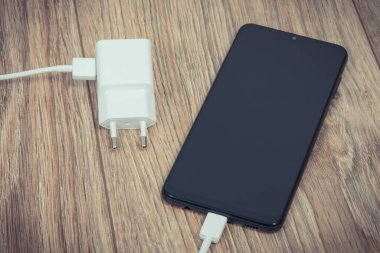 Siyah akıllı telefon, şarjlı cep telefonu. Çeşitli aygıtlar şarj etme kavramı