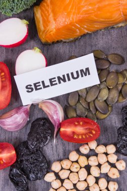 Selenyum, diyet lifleri ve diğer çeşitli vitamin ve mineraller içeren sağlıklı yiyecekler. Siyah tahta arkaplan