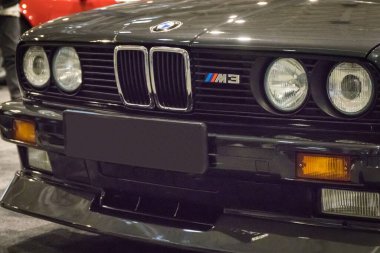Poznan, Polonya - 07 Ekim 2023: Retro Motor Show. Poznan 'daki Uluslararası Fuar. Parlak siyah BMW M3 'ün önüne bak. Ayrıntı ve aracın parçası