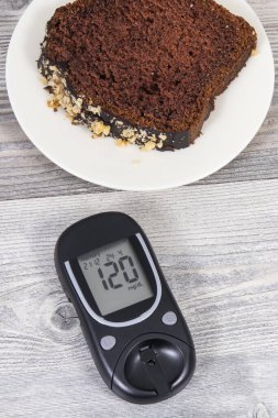 Glikoz ölçer, yüksek şeker seviyesi ve tatlı çikolatalı pasta sonucu oluşmuş. Diyabet konsepti sırasında besin