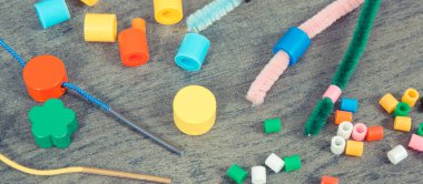 İplik, yaratıcı çubuklar ve bilezik yapımında kullanılan renkli boncuklar, saymayı ve çeşitli şekilleri sıralamayı öğrenin. Çocukların motor becerilerinin, yaratıcılığın, koordinasyonun ve mantıksal düşüncenin gelişimi