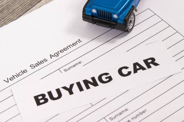 Küçük mavi oyuncak araba ve araç satış anlaşması. Araba satın alma yazıtları. Satışlar ve yeni ya da kullanılmış araba alımları