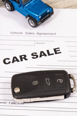 Küçük mavi oyuncak araba, siyah anahtar ve araç satış anlaşması. Araba satışı. Satışlar ve yeni ya da kullanılmış araba alımları