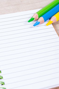 Notlar ve renkli kalemler için not defteri. Okulda ya da anaokulunda kullanılan ofis ve kırtasiye araçları