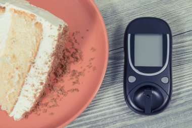 Glukometre, şeker seviyesini ölçmek ve bir parça çikolatalı tatlı kek için kullanılır. Diyabet konsepti sırasında sağlıklı yaşam tarzı