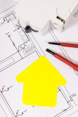Kurulum için elektrik bileşenleri, iş aletleri ve ev şeklinde sarı kağıt. Elektrik inşaat şemaları. Ev inşa etme ya da satın alma fikri. Teknoloji