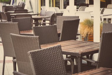 Hasır ya da rattan yapılmış sandalyeler ve restoran ya da kafe terasında masalar. Temiz havada dinlenme zamanı.