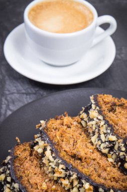 Siyah tabakta taze pişmiş kabak hamuru ve bir fincan beyaz kahve. Tatlı nefis.