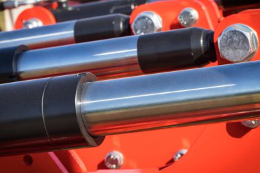 Kırmızı pnömatik ya da hidrolik makinede siyah pistonlar ya da aktivatörler. Teknoloji ve mühendislik