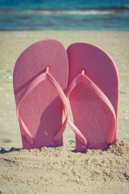 Kumsalda kumsalda pembe terlikler. Yaz zamanı dinlenmek için aksesuarlar