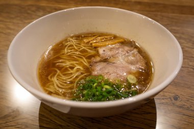 Japon Shoyu soya soslu ramen eriştesi marine edilmiş bambu filizleri (menma), yeşil soğan ve dilimlenmiş barbekü ve haşlanmış domuz eti (chashu). 
