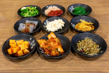 Kimçi, turp turşusu, ançüez, konjac, baharatlı fasulye ezmesi ve deniz yosunu gibi çeşitli Kore ev yemekleri. Genelde her yemekte servis edilir..