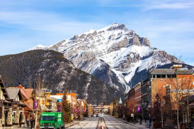 BANFF, CANADA - 22 Şubat 2024: Banff Ulusal Parkı 'ndaki Banff Bulvarı üzerinde Majestic Cascade Dağı görünüyor. Kasaba, dağlık çevresi ve kaplıcalarıyla ünlü büyük bir Kanada turizm beldesi..