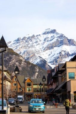 BANFF, CANADA - 22 Şubat 2024: Banff Ulusal Parkı 'ndaki Banff Bulvarı üzerinde Majestic Cascade Dağı görünüyor. Kasaba, dağlık çevresi ve kaplıcalarıyla ünlü büyük bir Kanada turizm beldesi..
