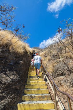 HONOLULU, HAWAII - 21 AUG 2023: Ziyaretçiler Oahu, Hawaii 'de popüler bir yürüyüş yolu olan ikonik Diamond Head Krateri' nin zirvesine çıkan bir tünelden merdivenlere tırmanıyorlar..