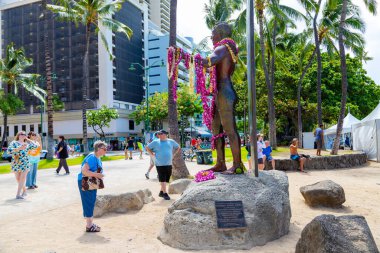 Honolulu, Oahu, Hawaii 'deki Waikiki plajında Dük Kahanamoku' nun 2,5 metrelik bronz heykeline hayran olan turistler. Ünlü heykel Hawaii Olimpiyat şampiyonu ve uluslararası sörfçünün babası onuruna yapıldı.