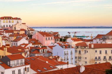 Miradouro das portas do sol bakış açısından Alfama üzerinde gün batımı Lizbon 'un en eski semtinde kırmızı çatılı geleneksel evleri gösteriyor..