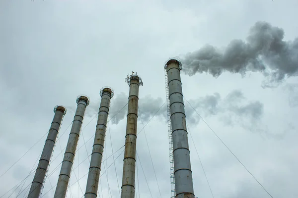 Buhar santrallerinden yükselen duman; gri bulutlar arka plan; hava kirliliği ve iklim değişikliği konsepti, Harkiv, Ukrayna