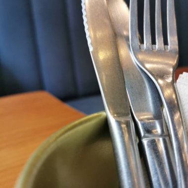 Cutlery in a bucket on a table in a cafe