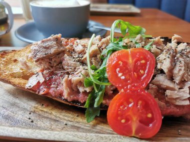 Tostada, ton balığı, domates ve otlu.