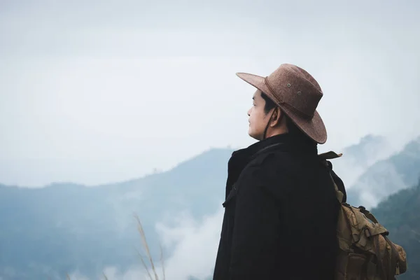 アジアの男性旅行者は 霧と雨の日に山の頂上に立っています 冒険と成功の概念旅行 — ストック写真